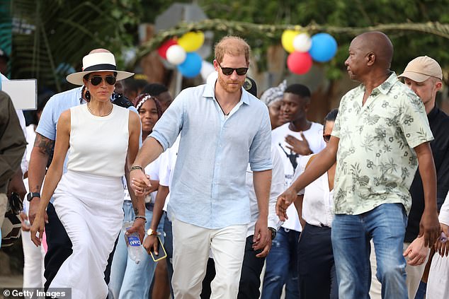 The Duke and Duchess of Sussex walk through the streets on day three of their visit