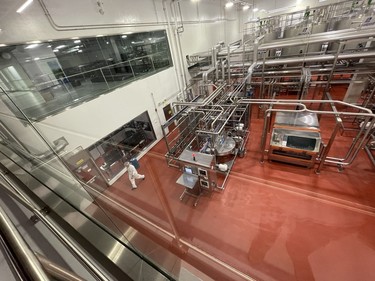 A worker walks past the control room for the receiving area where raw milk is first brought into the Canada Royal Milk facility in Kingston, Ont. on Tuesday, August. 13, 2024. Elliot Ferguson/The Whig-Standard/Postmedia Network