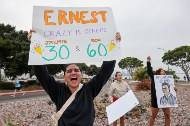 Diana Wong, left, Alexa Silva, center, and Ashely Knights, cheer on friends that are father and daughter as they and thousands of people participating in the half marathon run on Harbor Island during the 47th annual America's Finest City Half Marathon and 5K in San Diego on Sunday, Aug. 18, 2024. Over 1,300 people participated in the 5K and more than 4,300 in the half marathon. (Hayne Palmour IV / For The San Diego Union-Tribune)