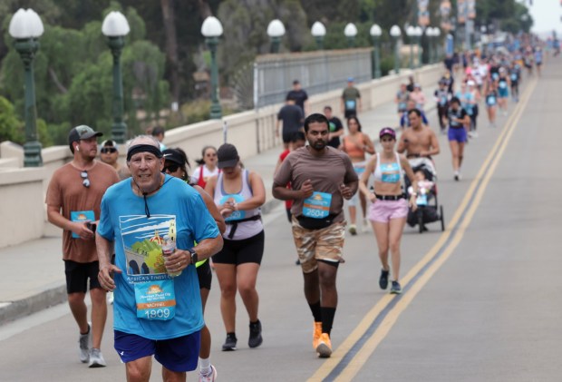 Half marathon runners make their way across the Cabrillo Bridge as they head toward the finish line in Balboa Park during the 47th annual America's Finest City Half Marathon and 5K in San Diego on Sunday, Aug. 18, 2024. Over 1,300 people participated in the 5K and more than 4,300 in the half marathon. (Hayne Palmour IV / For The San Diego Union-Tribune)