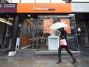 A woman walks past a Freedom Mobile story in Toronto on November 24, 2016.