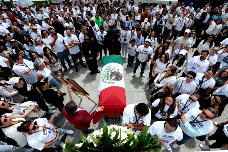 Judicial branch workers on strike sing the national anthem around a coffin wrapped with a Mexican national flag in front of the Federal Judicial Branch building in Zapopan, Mexico, on Aug. 19.