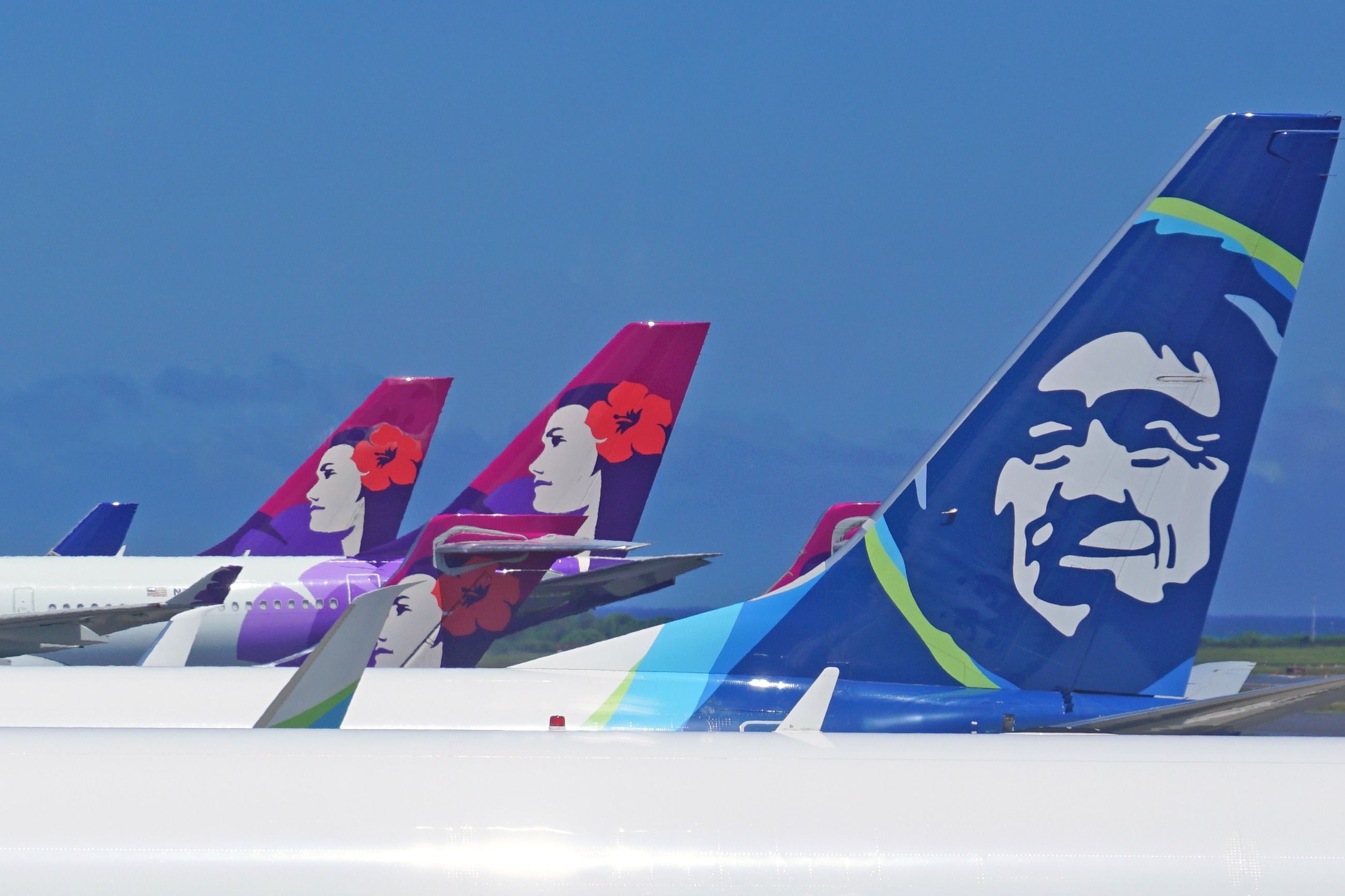 Alaska Airlines and Hawaiian Airlines tails.