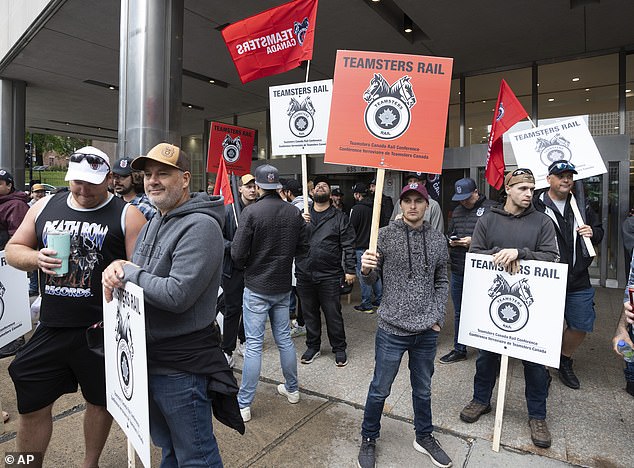 All rail traffic in Canada and all shipments crossing the US border have stopped, although CPKC and CN's trains will continue to operate in the US and Mexico. Pictured: Rail workers picket in front of CN headquarters in Montreal today