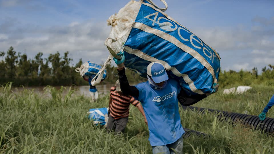 Local employees gather the trash in large blue sacks. - 4ocean/Clynton Guzman