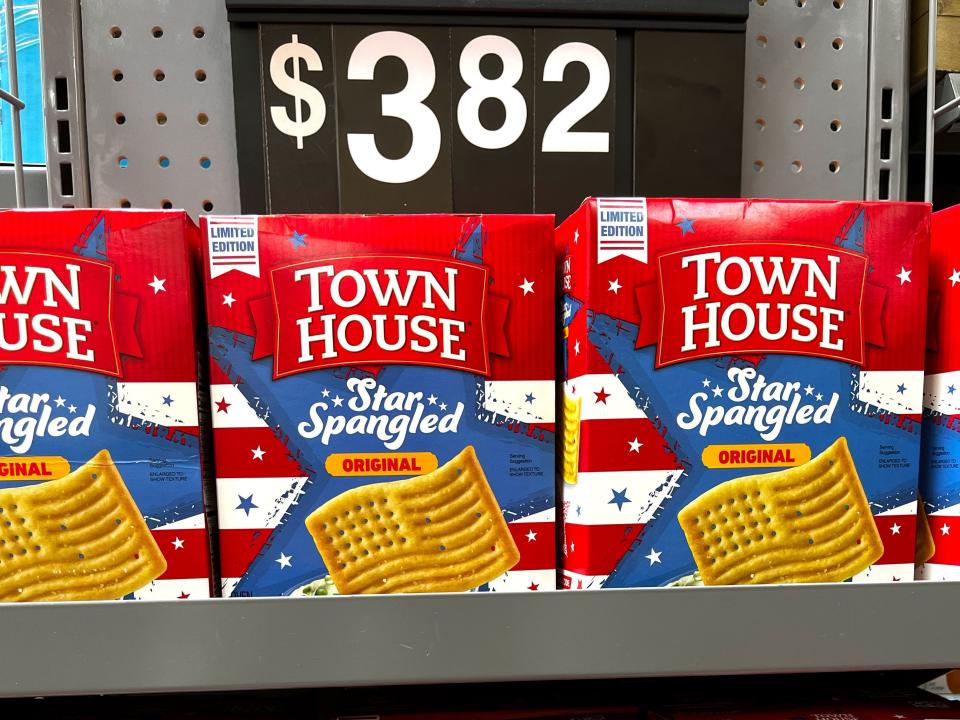 Boxes of flag-shaped Town House cookies on shelves at a store, with a price tag that says $3.82.