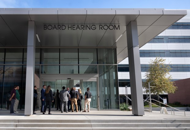 People wait outside before a Board of Supervisors meeting takes...