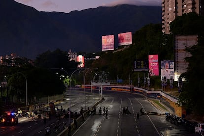 Baruta Municipal Police remove a barricade as people protest against the election results that gave President Nicolás Maduro a third term.