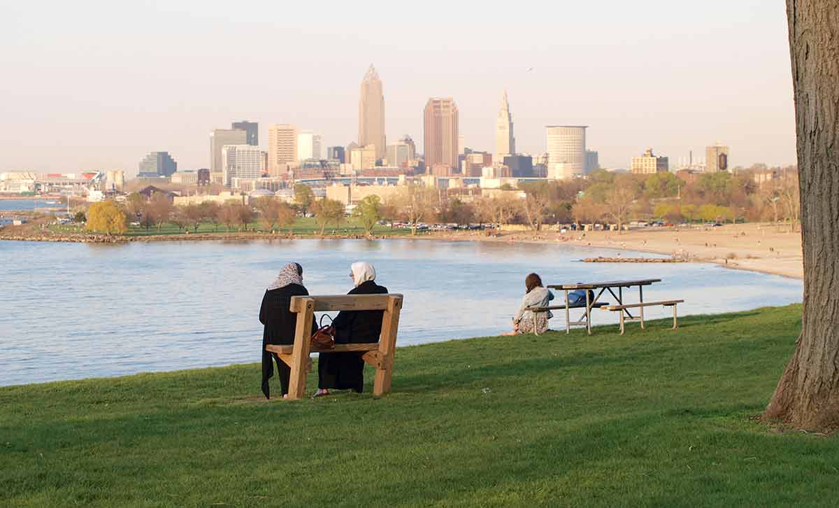 clean beaches in new york scene of two women in middle eastern veils sitting in the park over looking Lake Erie