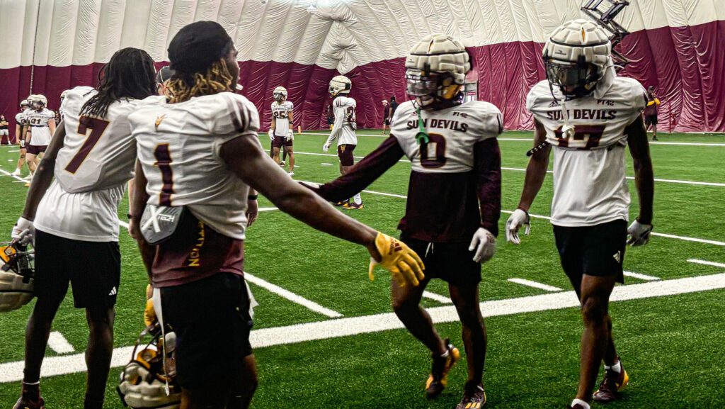 Arizona State defensive backs Cole Martin (#0) and Rodney Bimage Jr. (#17) greet teammates after br...