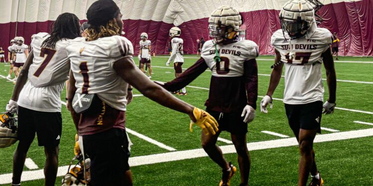 Arizona State defensive backs Cole Martin (#0) and Rodney Bimage Jr. (#17) greet teammates after br...
