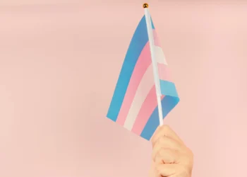 Hand holding flag in transgender pride colours