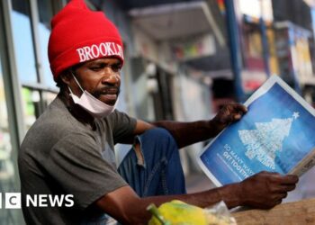 Man reads local Barbadian newspaper