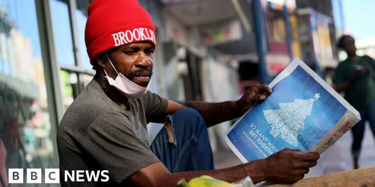 Man reads local Barbadian newspaper