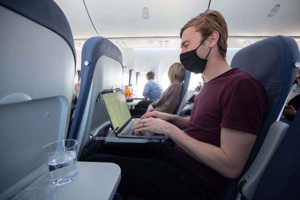 A man is working on his laptop on a Lynx MAX. 