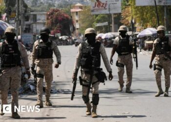 Police patrol a street in Port-au-Prince, Haiti