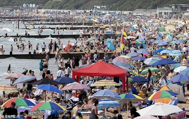 Parts of the UK saw temperatures as high as 34.8C on Monday - a two-year record set in Cambridge - as people made the most of it in parks and beaches (Bournemouth pictured)