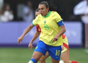 Marta on the ball for Brazil, in a yellow shirt and blue shirts, in the women