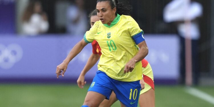 Marta on the ball for Brazil, in a yellow shirt and blue shirts, in the women