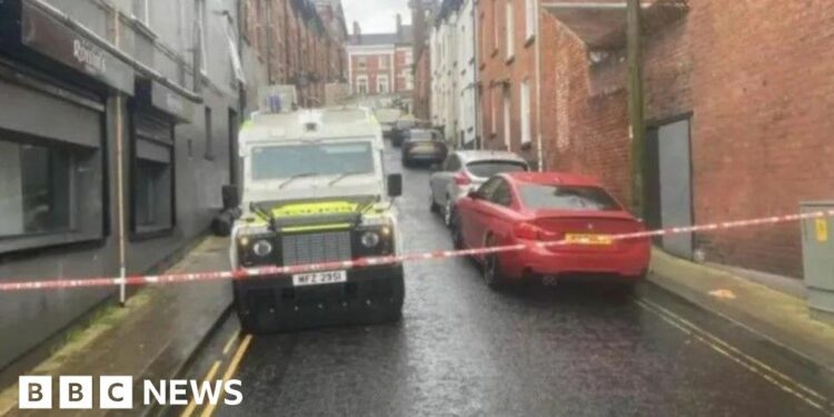 Shows a police Land Rover and cordon
