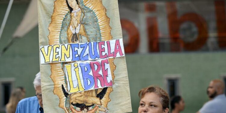 A woman holds an image of Our Lady of Guadalupe with the words Free Venezuela during a vigil called by the opposition demanding freedom for political prisoners arrested during protest following the contested re-election of Venezuelan President Nicolas Maduro in Caracas, August 8, 2024.