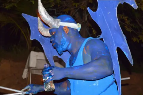 Anselm Gibbs Samuel Thomas performs as a blue devil