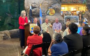 Katie Hobbs in a red blazer speaks at a podium with the 