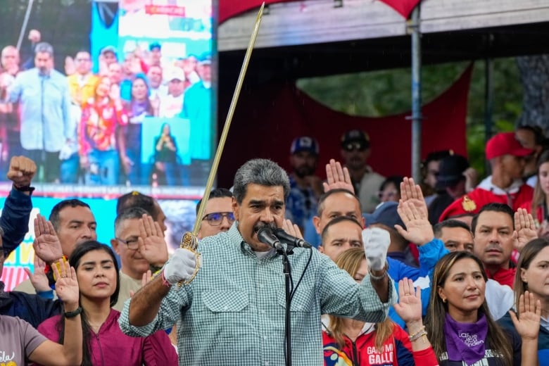 Venezuela's President Nicolás Maduro brandishes a sword as his new cabinet takes the oath of office at the presidential palace in Caracas, Venezuela on Wednesday, Aug. 28, 2024.