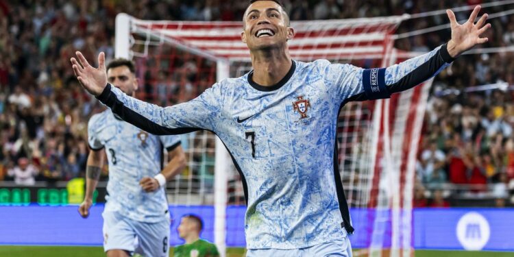 Cristiano Ronaldo celebrates his 900th career goal in a blue and white Portugal top.