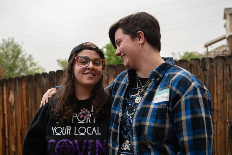 Livia Demopoulos and Tori stand outside, one wearing glasses and a black 