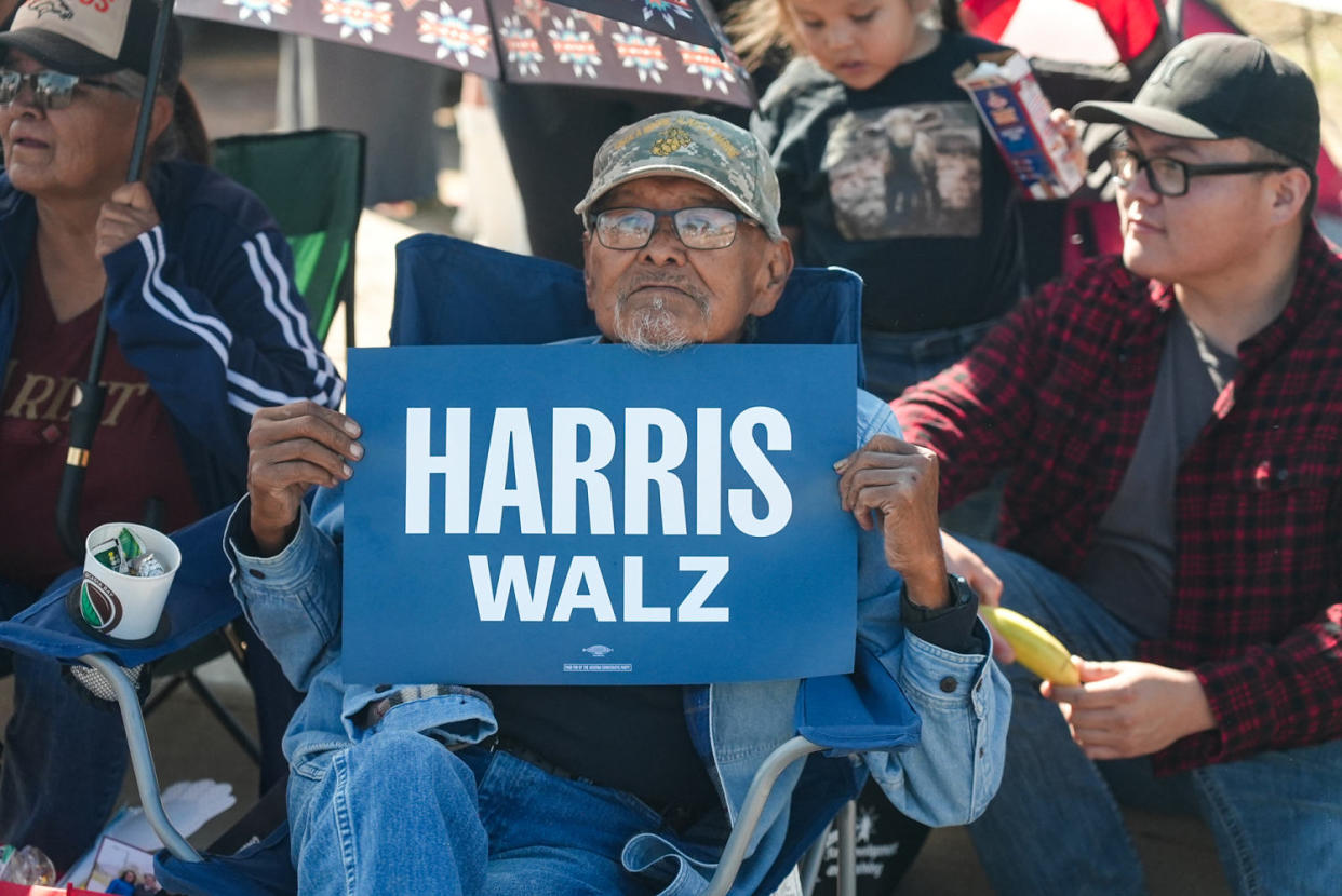 A man holds a Harris-Walz sign at the Navajo Nation parade in Window Rock, Ariz. (Alex Tabet / NBC News)