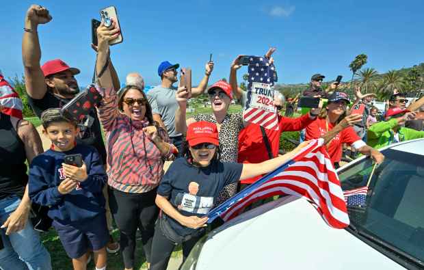 Hundreds of Donald Trump supporters line Trump National Road and...