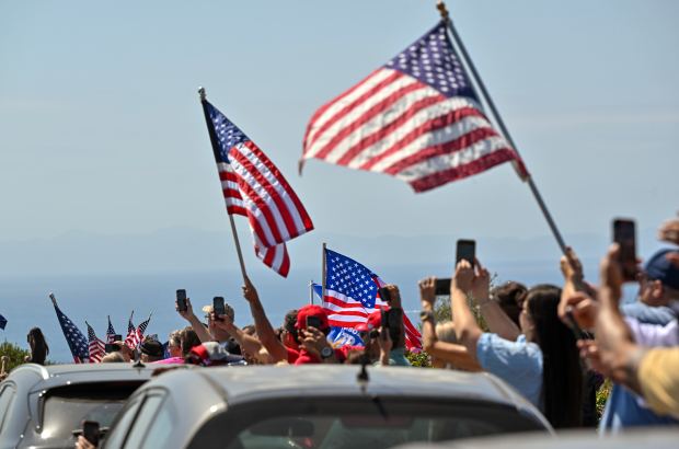 Hundreds of Donald Trump supporters line Trump National Road as...