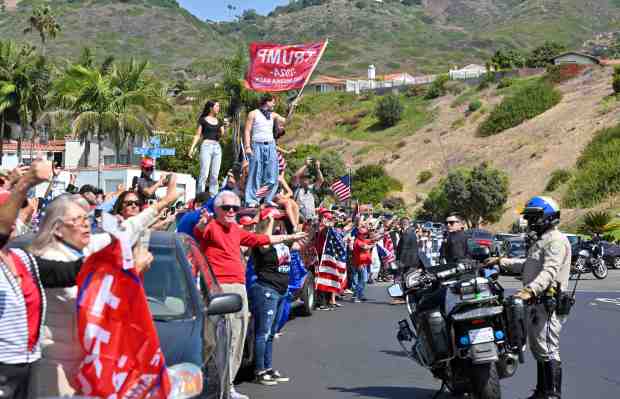 Hundreds of Donald Trump supporters line Trump National Road and...