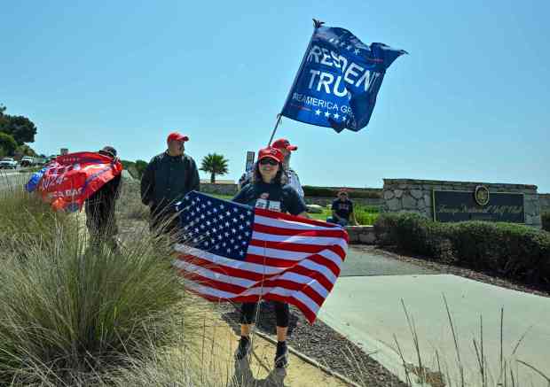 Donald Trump supporters near the entrance of Trump National Golf...