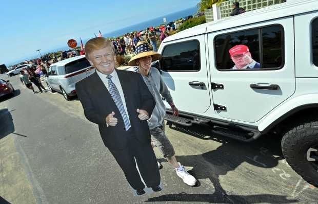 Donald Trump supporters crowd the intersection of Trump National Road...