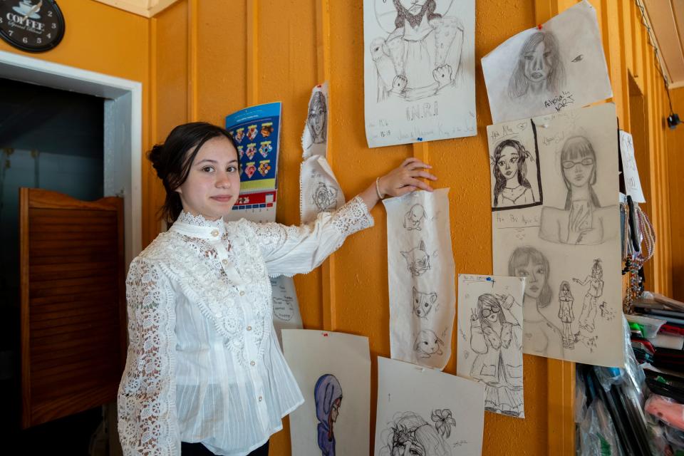 Alysia Sou, 14, points to some of the many drawings she has made that adorn the walls of her mother’s business, Hope Donuts in Hope, Arkansas. Sou hopes to be accepted to Hope Collegiate Academy, a program that enables students to earn their high school diploma and an Associate Degree at the same time.