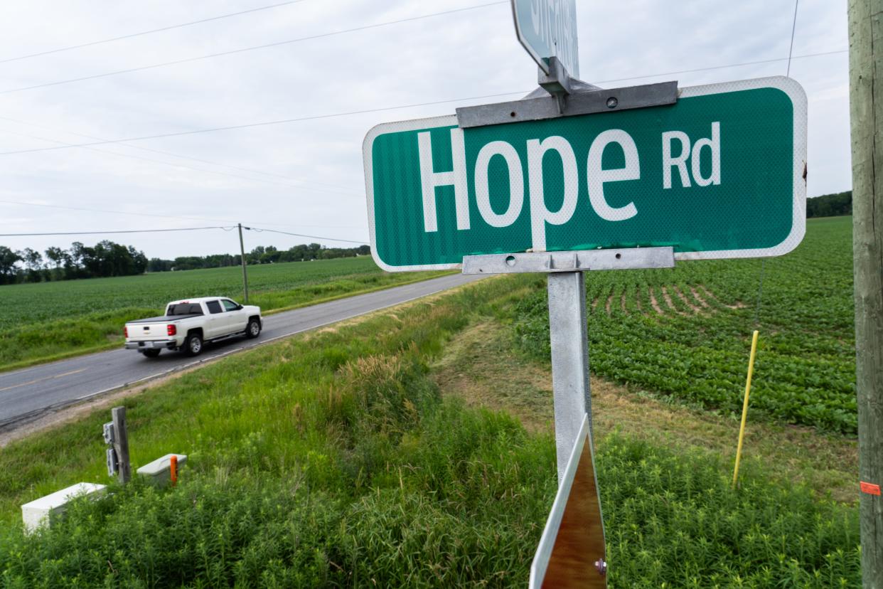 A truck moves past farmland along Hope Road in Hope Township.