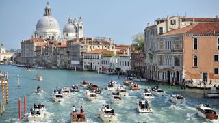 A fleet of boats driving down the Venice canals