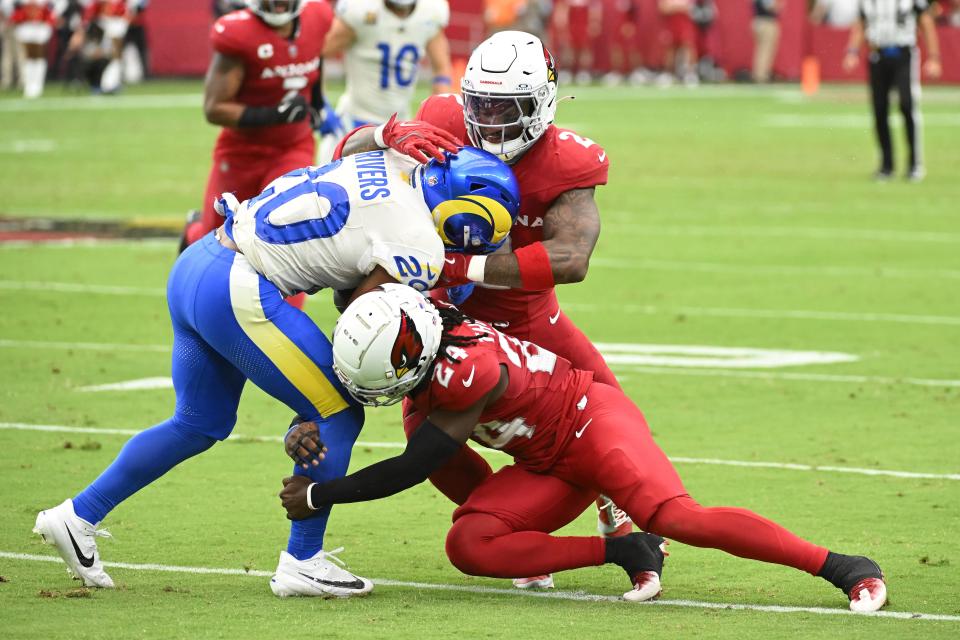 GLENDALE, ARIZONA - SEPTEMBER 15: Cam Hart #20 of the Los Angeles Chargers is tackled by Starling Thomas V #24 and Mack Wilson Sr. #2 of the Arizona Cardinals during the second quarter at State Farm Stadium on September 15, 2024 in Glendale, Arizona. (Photo by Norm Hall/Getty Images)