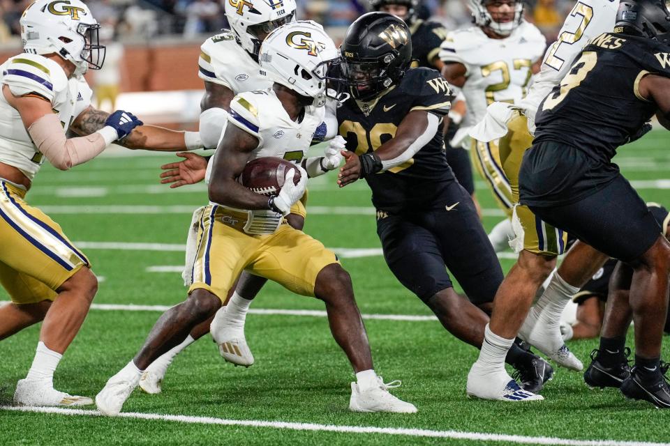 Sep 23, 2023; Winston-Salem, North Carolina, USA; Wake Forest Demon Deacons defensive back Jamare Glasker (25) tackles Georgia Tech Yellow Jackets wide receiver Christian Leary (6) during the second half at Allegacy Federal Credit Union Stadium. Mandatory Credit: Jim Dedmon-USA TODAY Sports