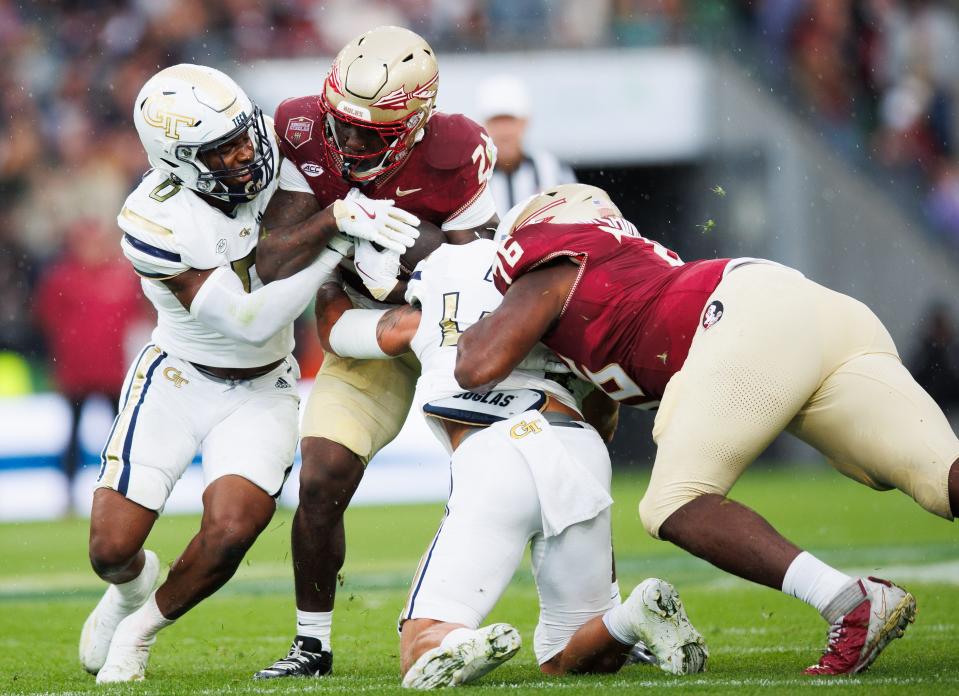 Aug 24, 2024; Dublin, IRL; Florida State University running back Roydell Williams is tackled by Trenilyas Tatum and Kyle Efford of Georgia Tech at Aviva Stadium. Mandatory Credit: Tom Maher/INPHO via USA TODAY Sports