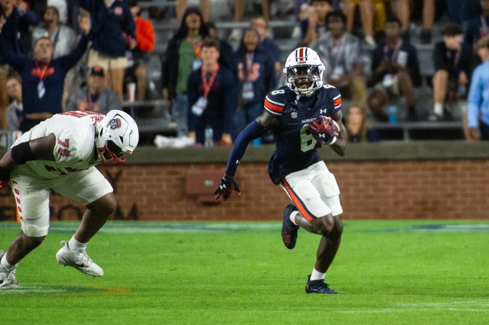 AUBURN, ALABAMA - SEPTEMBER 14 : Cornerback Antonio Kite #8 of the Auburn Tigers runs the ball past offensive lineman Richard Pearce #78 of the New Mexico Lobos after intercepting the ball during the second half of play at Jordan-Hare Stadium on September 14, 2024 in Auburn, Alabama. (Photo by Michael Chang/Getty Images)