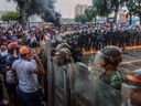 Demonstrators confront riot police during a protest against Venezuelan President Nicolas Maduro's government in Puerto La Cruz, Anzoategui state, Venezuela on July 29, 2024, a day after the Venezuelan presidential election. (Photo by CARLOS LANDAETA/AFP via Getty Images)