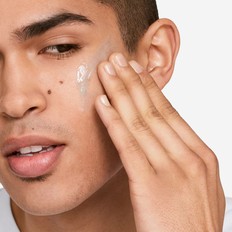 A man applying moisturizer to his face.