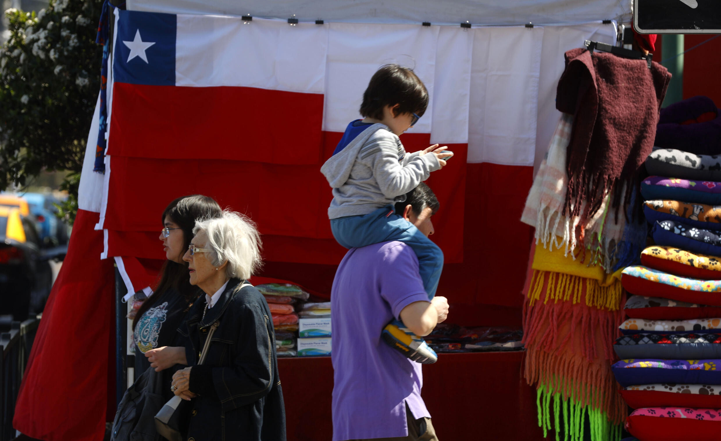 Un hombre lleva a su hijo a hombros en un mercado de Santiago el 6 de septiembre de 2024.