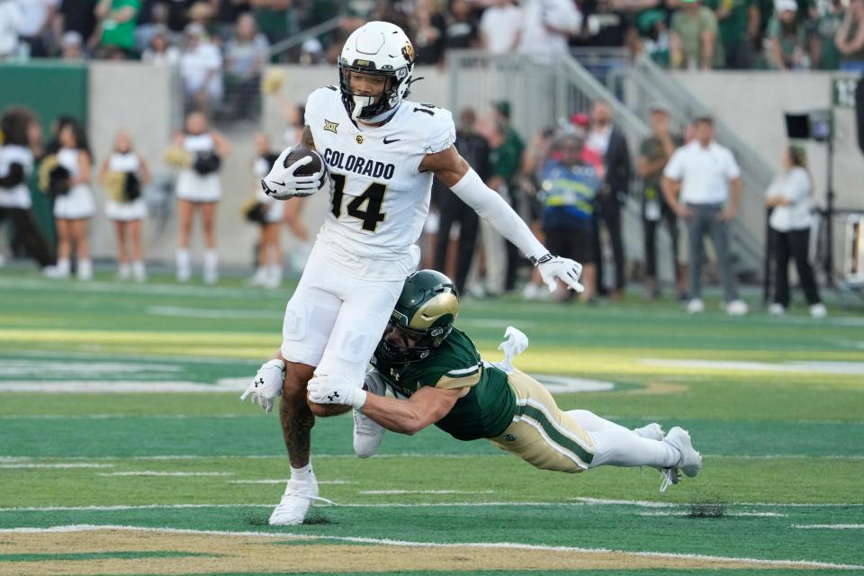 Sep 14, 2024; Fort Collins, Colorado, USA; Colorado Buffaloes wide receiver Will Sheppard (14) is tackled from behind by Colorado State Rams defensive back Jack Howell (17) Sonny Lubick Field at Canvas Stadium. Mandatory Credit: Michael Madrid-Imagn Images