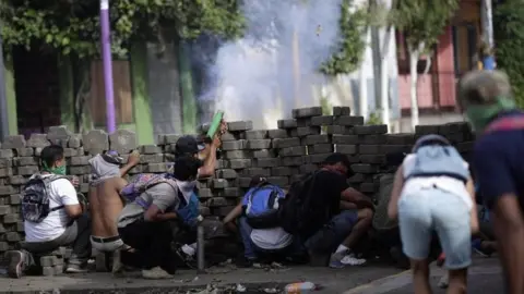 EPA Protesters take cover behind a makeshift barrier during ongoing protests in Masaya, Nicaragua, 09 June 2018. Nicaragua saw renewed protests after President Daniel Ortega failed to respond to a letter calling for 