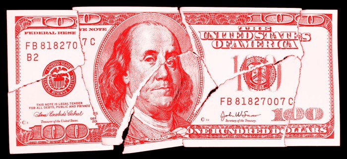 A crumpled and torn red $100 bill