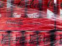 This photograph shows Coca-Cola soft drink cans wrapped in plastic in Paris on September 16, 2024.